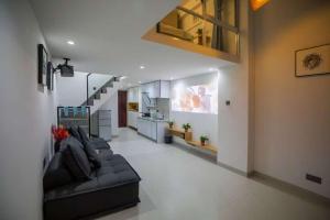 a living room with a couch and a kitchen at Qixin Homestay in Changsha