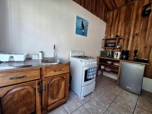 a kitchen with a stove top oven next to a sink at Monteverde Cecropia Paradise in Monteverde Costa Rica