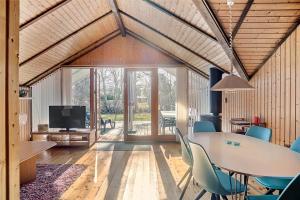 a dining room with a table and chairs and a tv at 3078-Stege-Maegleren-18 in Stege