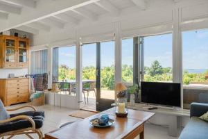 a living room with a tv and large windows at 8220-Vordingborg-Solbaervej-6 in Vordingborg