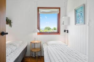 a small bedroom with two beds and a window at 8220-Vordingborg-Solbaervej-6 in Vordingborg