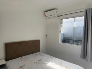 een slaapkamer met een bed en een raam bij Loft novo e bem localizado in Biguaçu