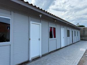 een rij witte garagedeuren op een gebouw bij Loft novo e bem localizado in Biguaçu