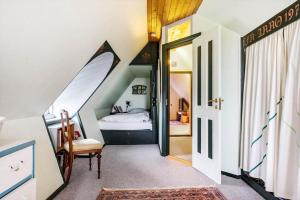 une petite chambre mansardée avec un lit et une porte dans l'établissement 4020-Stege-Udbyvej-10, à Stege