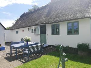 une maison blanche avec une table de pique-nique devant elle dans l'établissement 4020-Stege-Udbyvej-10, à Stege