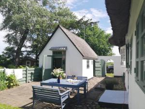 une petite maison blanche avec une table et des chaises bleues dans l'établissement 4020-Stege-Udbyvej-10, à Stege 19 autres photos
