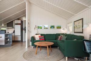 een woonkamer met een groene bank en een tafel bij 3064-Stege-Maegleren-34 in Stege