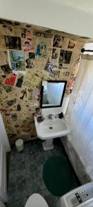a bathroom with a sink and a tv on the wall at Viña acogedor lugar a pasos del reloj de flores in Viña del Mar