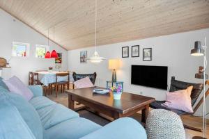 een woonkamer met een blauwe bank en een tafel bij 3046-Stege-Paelen-46 in Stege