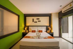 a bedroom with a large bed with green walls at Star House Patong in Patong Beach