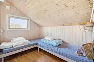 a bed in a room with a wooden ceiling at OH123-Storvorde-Kongeornen-3 in Storvorde