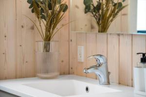 a bathroom sink with a vase with flowers in it at OH419-Hadsund-Halvrebene-60 in Hadsund