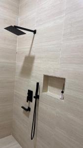 een badkamer met een douche met een zwarte slang op de vloer bij Riva chalet in Badīyah