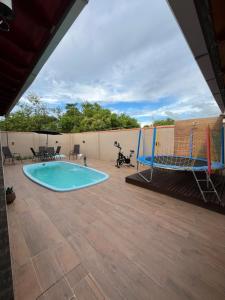 a large patio with a pool and a volleyball hoop at Habitación Maninha in Pântano Grande +11 photos