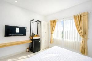 a bedroom with a bed and a tv and a window at Đại Phú Hotel Hồ Chí Minh in Ho Chi Minh City