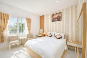 a white bedroom with a bed and a window at Đại Phú Hotel Hồ Chí Minh in Ho Chi Minh City