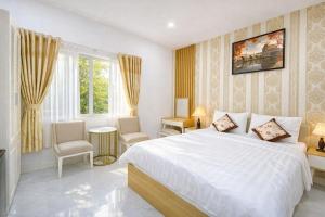 a bedroom with a white bed and a window at Đại Phú Hotel Hồ Chí Minh in Ho Chi Minh City