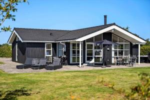 a black house with chairs and an umbrella at OH449-Hadsund-Haslevgarde-Eng-49 in Hadsund