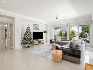 - un salon avec un arbre de Noël et un canapé dans l'établissement Jacksons Coast House, à Mount Eliza