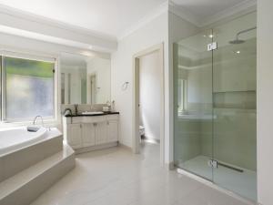 une salle de bain avec baignoire et douche en verre dans l'établissement Jacksons Coast House, à Mount Eliza 24 autres photos