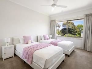 - 2 lits dans une chambre blanche avec fenêtre dans l'établissement Jacksons Coast House, à Mount Eliza