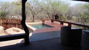 a deck with a plunge pool on a patio at Marloth Kruger Whispering Ants in Marloth Park