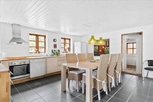 een keuken en eetkamer met een tafel en stoelen bij HA186-Saeby-Lynglund-6 in Sæby