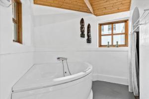 een witte badkamer met een bad en een toilet bij HA186-Saeby-Lynglund-6 in Sæby +16 foto's