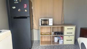 a kitchen with a microwave and a refrigerator at Cosy studio in Port Louis
