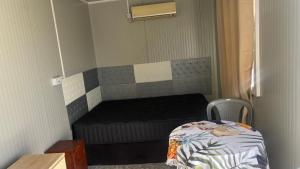 a small room with a bed and a chair at Cosy studio in Port Louis