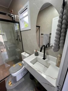 a bathroom with a sink and a toilet and a mirror at Habitación Maninha in Pântano Grande