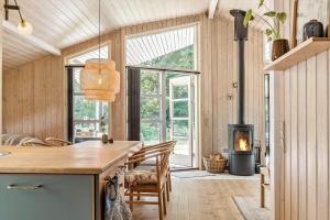 a kitchen with a table and a wood stove at OH185-Hadsund-Sommerland-39 in Hadsund