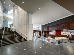 eine Lobby eines Gebäudes mit Treppen und Stühlen in der Unterkunft Sofitel Chicago Magnificent Mile in Chicago