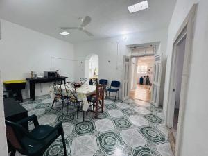 een woonkamer met een tafel en stoelen op een tegelvloer bij Casa Playa Blanca in Progreso +33 foto's