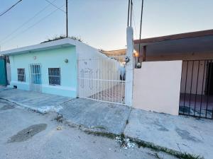 a white building with a gate in front of it at Casa Playa Blanca in Progreso