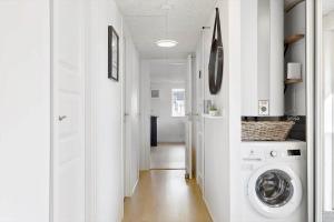 a hallway with a washer and dryer in a house at OH292-Hadsund-Stenkisten-108 in Hadsund