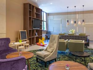 un salon avec un canapé, des chaises et des tables dans l'établissement Mercure Jelenia Góra, à Jelenia Góra