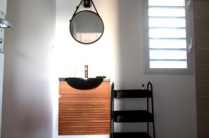 a bathroom with a sink and a mirror at Gîte soufrière in Saint-Claude