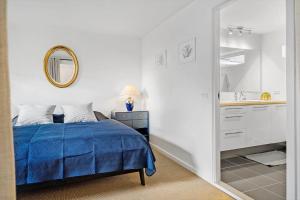 una camera da letto con un letto blu e uno specchio di HA318-Hals-Merkurvej-73 a Hals