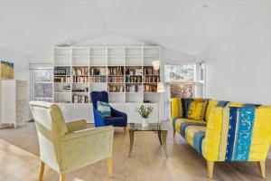 un soggiorno con divano, sedie e libreria di HA318-Hals-Merkurvej-73 a Hals