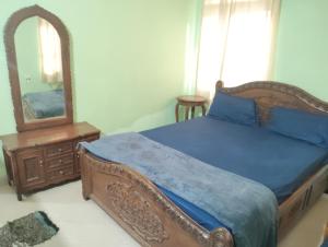 a bedroom with a bed and a dresser and a mirror at Richnest Apartment and villas Colva in Colva