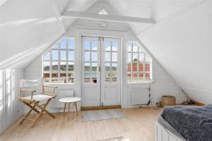 een slaapkamer met een bed, een stoel en een raam bij OH409-Hadsund-Vesterled-2 in Hadsund