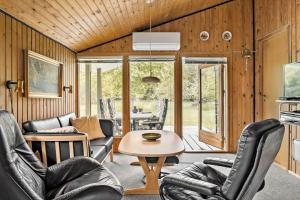 een woonkamer met lederen stoelen en een tafel bij HA306-Asaa-Strandgardsvej-68 in Aså