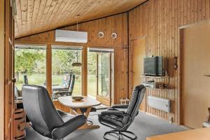 een woonkamer met stoelen, een tafel en een tv bij HA306-Asaa-Strandgardsvej-68 in Aså