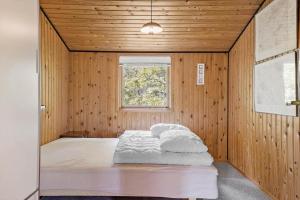 een bed in een houten kamer met een raam bij HA306-Asaa-Strandgardsvej-68 in Aså