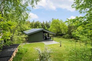 een klein groen gebouw midden in een tuin bij HA306-Asaa-Strandgardsvej-68 in Aså