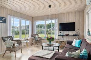 een woonkamer met een bank, stoelen en een tv bij OH359-Storvorde-Kongeornen-62 in Storvorde