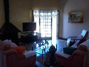 uma sala de estar com dois sofás e uma televisão em Casa das Palmeiras + Quiosque em Bento Gonçalves