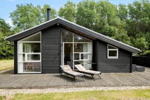 een zwart huis met twee stoelen op een terras bij HA173-Asaa-Knirren-6-B in Aså