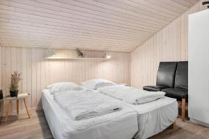 una camera da letto con un grande letto bianco e una sedia di HA178-Hals-Lyngtoftegaard-2 a Hals